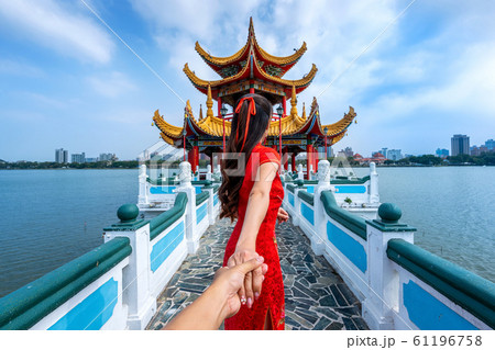 Women tourists holding man's hand and leading him to Kaohsiung's famous tourist attractions in Taiwan. 61196758