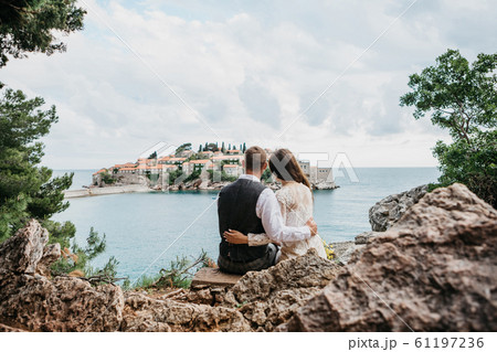 Couple looks at the island of Sveti Stefan in 61197236