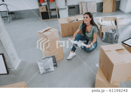 Happy young lady is looking up at her new home 61198248