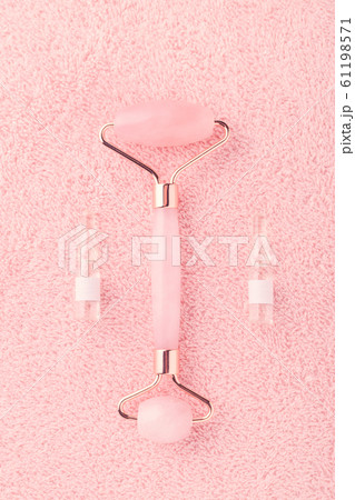 real rose quartz facial roller and face serum in ampoules on pink background real rose quartz facial roller and face serum in ampoules on pink background 61198571