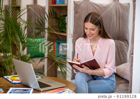 Young female designer working in her office. Young female designer working in her office. 61199128