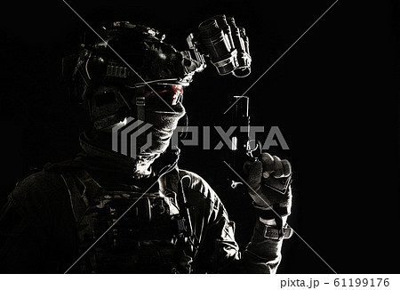 Combatant armed with service pistol in darkness 61199176