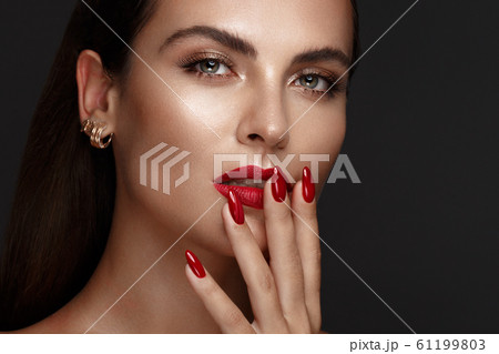 Beautiful girl with a classic make-up and red nails. Manicure design. Beauty face. 61199803