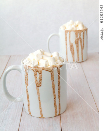 Hot cocoa in white mugs with chocolate drops 61202542