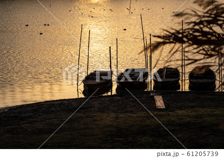 冬の水辺 夕刻のきらめく水面 小舟のシルエット　a 61205739