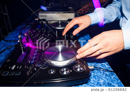 club DJ mixing music on a mixer in a nightclub 61206682