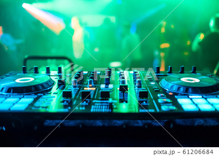 DJ booth at night club party for music mixing with green blurred background 61206684