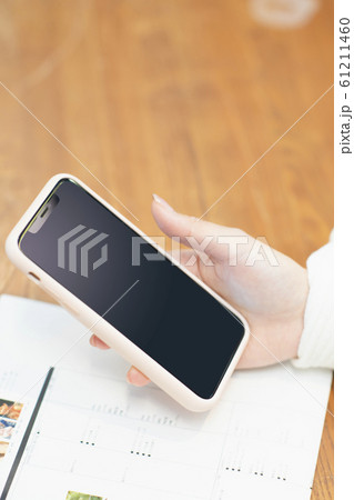 スマートフォンを持つ女性の手元 61211460
