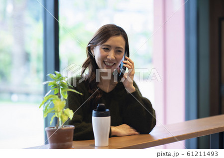 カフェで通話する女性 61211493