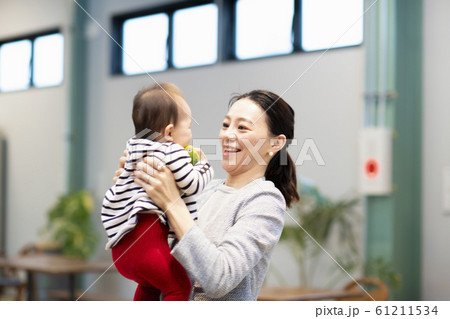 赤ちゃんをあやす女性 61211534