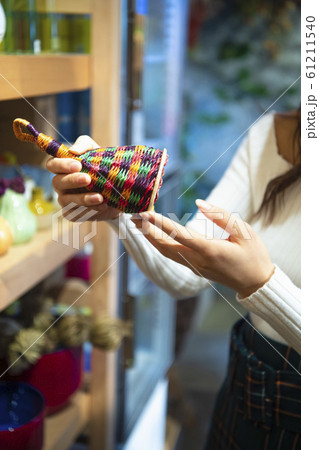 フラワーショップで商品を手に取る女性 61211540