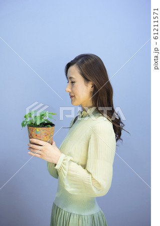 ペパーミントの鉢植えを持つ女性 ペパーミントの鉢植えを持つ女性 61211571