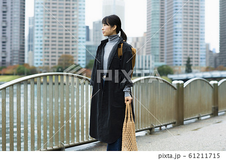 川辺を歩く女性 61211715