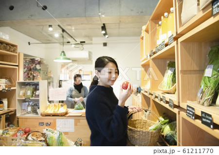 八百屋で有機野菜を選ぶ女性 八百屋で有機野菜を選ぶ女性 61211770
