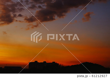 Silhouette of Beautiful sunset with Building. Orange sky with sun and clouds. Nature background. 61212927