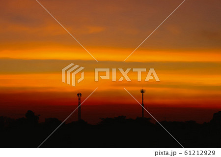 Silhouette of Beautiful sunset with television antenna or telecommunications towers have a lot of different antennas, Orange sky with sun and clouds. Nature background. 61212929
