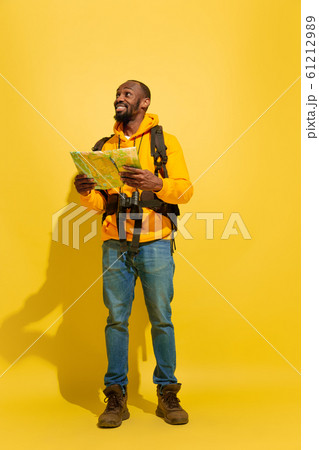 Full length portrait of a cheerful young african tourist guy isolated on yellow background 61212989