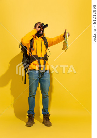 Full length portrait of a cheerful young african tourist guy isolated on yellow background Full length portrait of a cheerful young african tourist guy isolated on yellow background 61212998