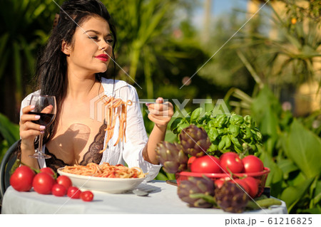 beautiful Woman in summer dress eats Italy 61216825
