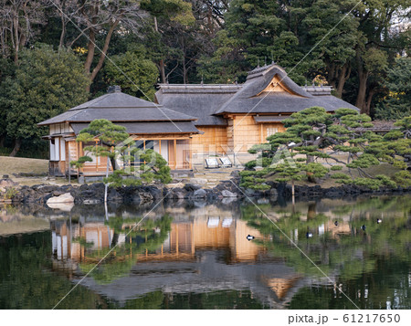 公園の池に反射する日本家屋の写真素材