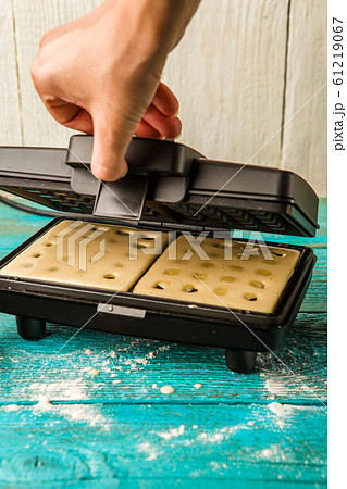 Making waffles at home - batter in waffle iron 61219067