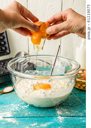 Making wafers at home. Adding eggs to the dough Making wafers at home. Adding eggs to the dough 61219075