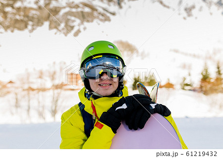 Image of sportive man wearing helmet with snowboard against background of snowy mountains Image of sportive man wearing helmet with snowboard against background of snowy mountains 61219432