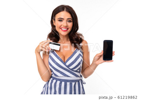 Pretty caucasian woman holds a credit card and mobile phone isolated on white background Pretty caucasian woman holds a credit card and mobile phone isolated on white background 61219862