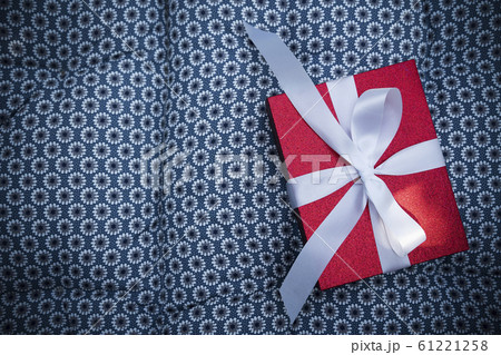 Red gift box with white bow on sofa with free 61221258