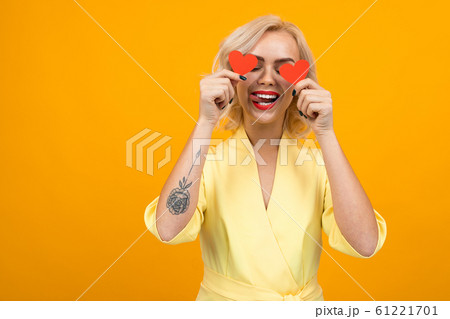 valentine's day concept. girl holds valentine`s cards by eye on yellow background valentine's day concept. girl holds valentine`s cards by eye on yellow background 61221701