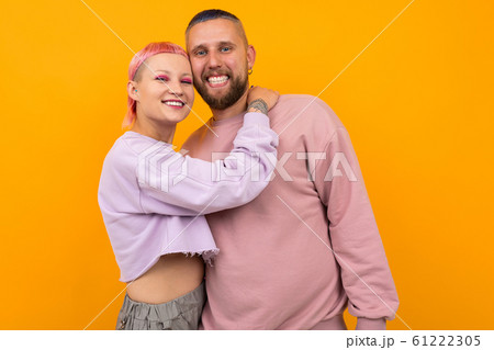 happy smiling couple of girl and guy with colored hair and piercing are standing in an embrace on a happy smiling couple of girl and guy with colored hair and piercing are standing in an embrace on a 61222305