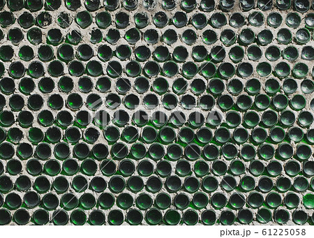 A wall of green wine bottles. Solid texture fence from the bottom A wall of green wine bottles. Solid texture fence from the bottom 61225058