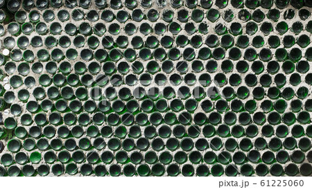 A wall of green wine bottles. Solid texture fence from the bottom A wall of green wine bottles. Solid texture fence from the bottom 61225060