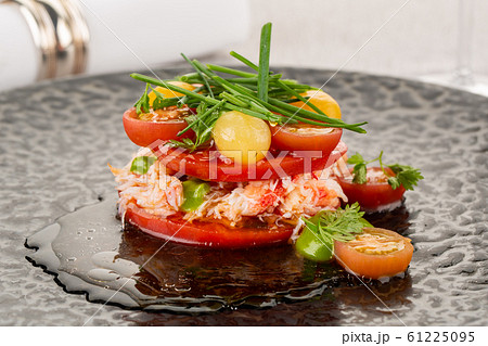 Crab meat with cherry tomatoes and greens, served with truffle sauce 61225095