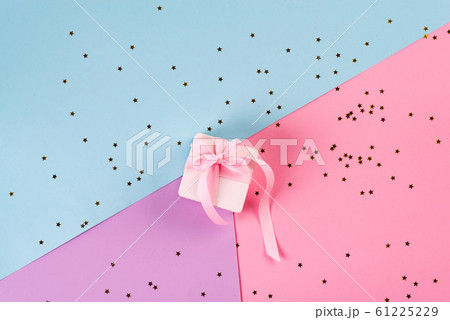 Gift or present box and sequins on pink table top view. Flat lay. Birthday, wedding or christmas concept. 61225229