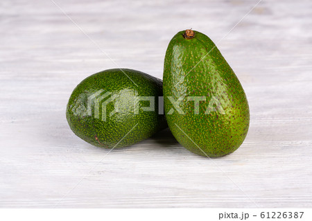 Green avocado on white wooden background 61226387