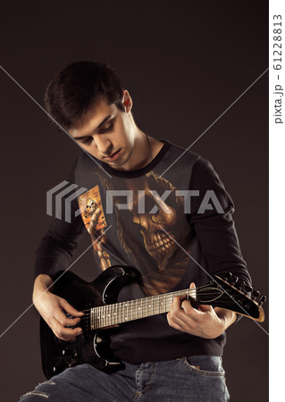 Handsome man playing electro guitar, studio shot Handsome man playing electro guitar, studio shot 61228813