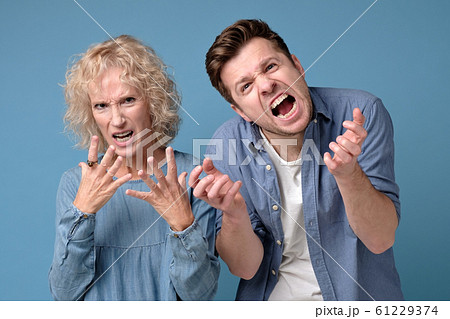 Young man and mature woman with a mad aggressive expression screaming 61229374
