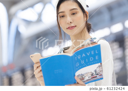 空港　旅行　女性　ガイドブック 61232424