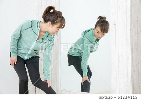 鏡でボディチェックする女性 61234115
