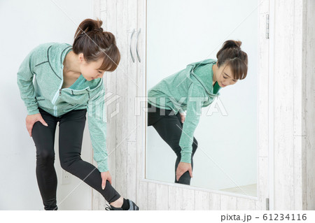 鏡でボディチェックする女性 61234116