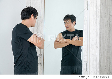 鏡の前でボディチェックする男性 61235054