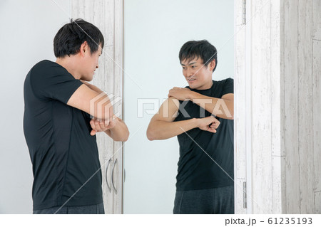 鏡の前でボディチェックする男性 61235193