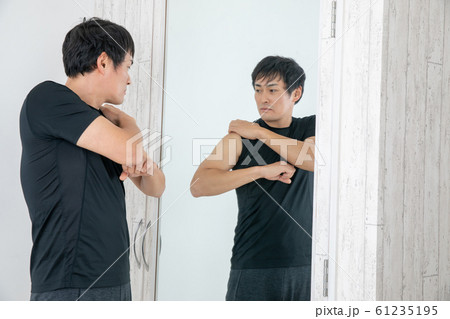 鏡の前でボディチェックする男性 61235195