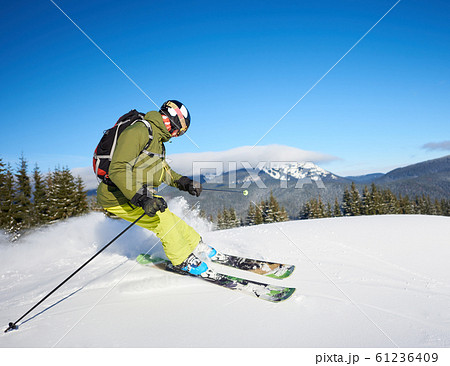 Young man backpacker skiing up and down slopes. Male skier training in sunny winter day. Backcountry skiing concept. Young man backpacker skiing up and down slopes. Male skier training in sunny winter day. Backcountry skiing concept. 61236409