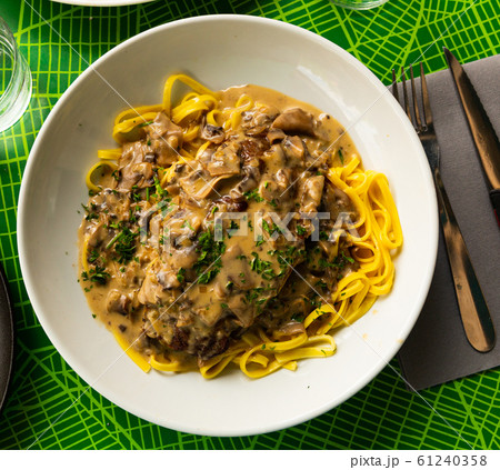 Pork ribs with mushroom sauce and linguine pasta. French cuisine 61240358