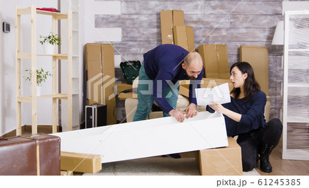 Young couple assembling furniture as a team in new apartment 61245385