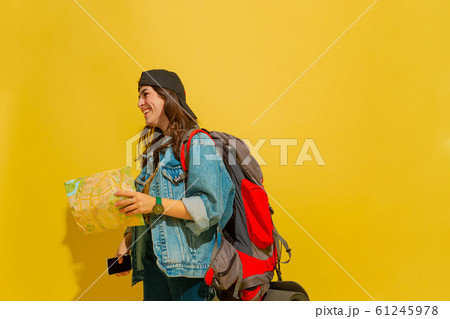 Portrait of a cheerful young caucasian tourist girl isolated on yellow background 61245978