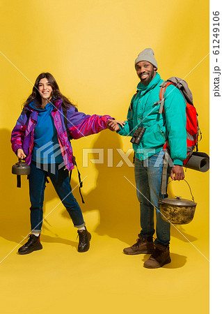 Portrait of a cheerful young tourist couple isolated on yellow background Portrait of a cheerful young tourist couple isolated on yellow background 61249106