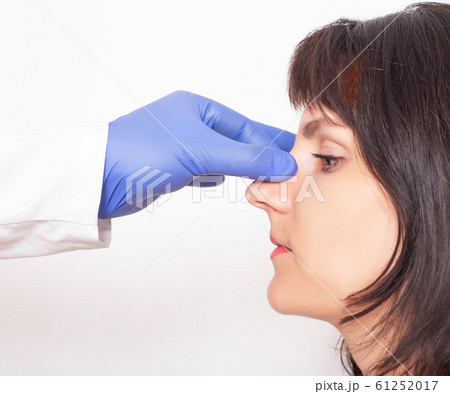 Doctor plastic surgeon prepares a caucasian girl for nose plastic surgery. Rhinoplasty 61252017